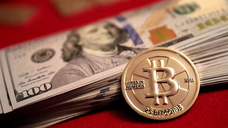 US hundred-dollar bills with a gold physical bitcoin