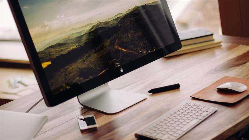 Desktop computer and keyboard on a wooden workstation