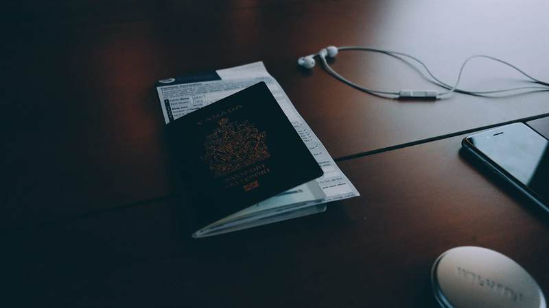 Passport and travel documents on a dark wooden desk