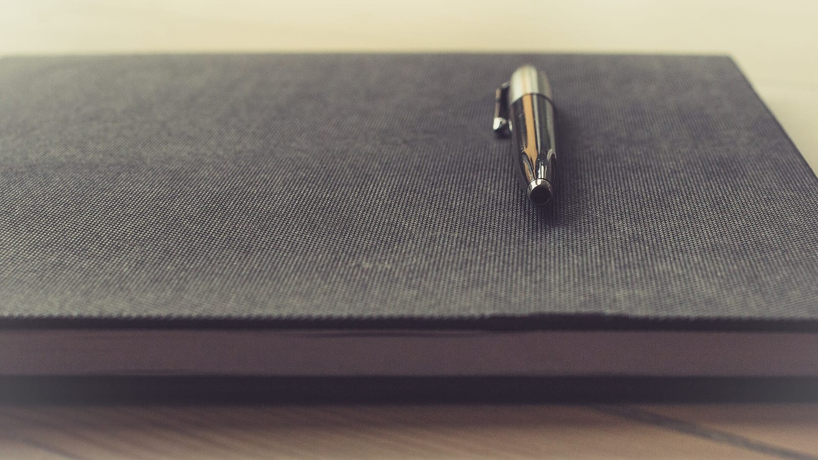 Closed notebook with a pen on the cover